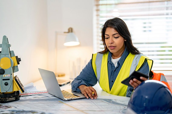 CIS Contractor looking at her paperwork while holding a calculator