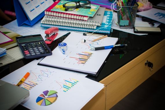 Competitor Research and Analysis A desk covered in notebooks, charts, pens and stationary to depict the process of competitor research