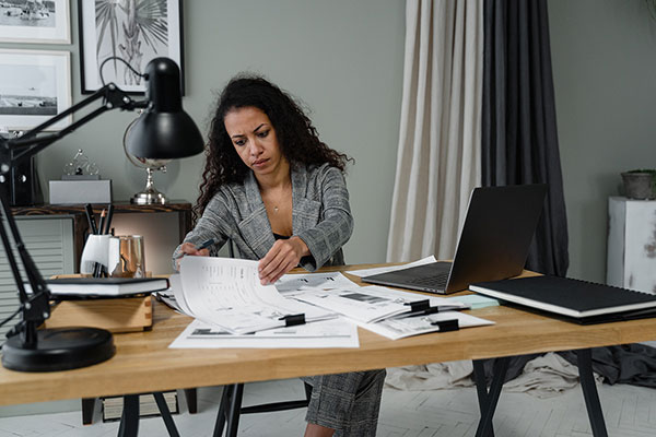A woman working through paperwork at her desk