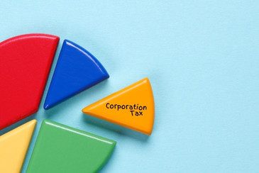 A selection of colourful blocks depicting a pie chart with a wedge pulled out with Corporation Tax written on it